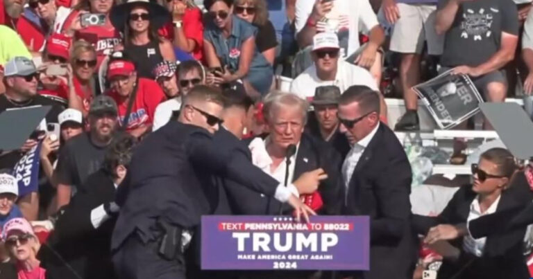 Secret Service agents help former president Donald Trump stand up to remove him from the stage after attempted assassination